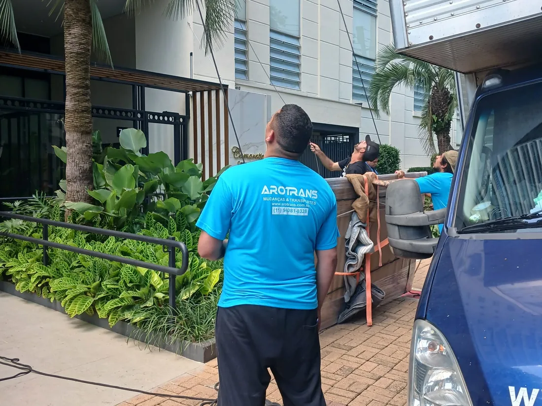 Equipe em operação de içamento junto ao caminhão